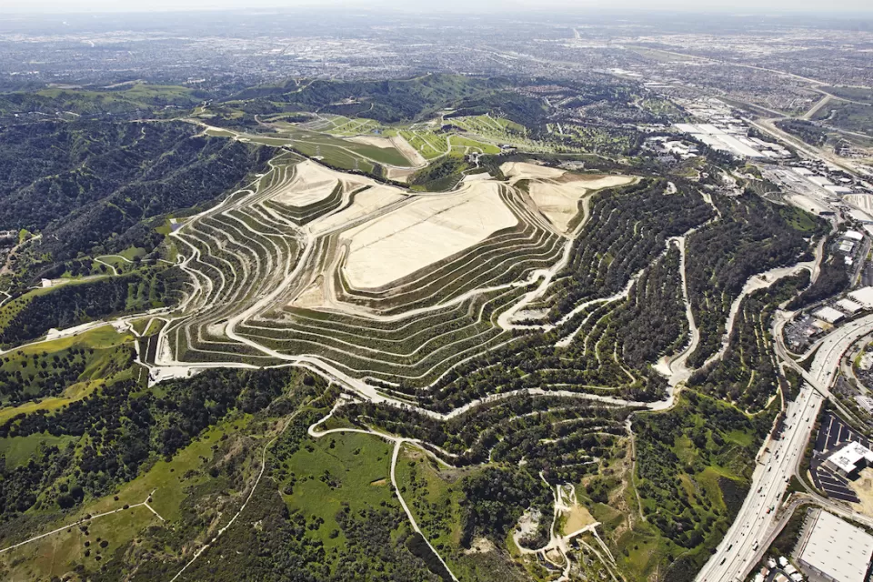 Aerial view of Puente Hills landfill on green hill in Los Angeles County, California.